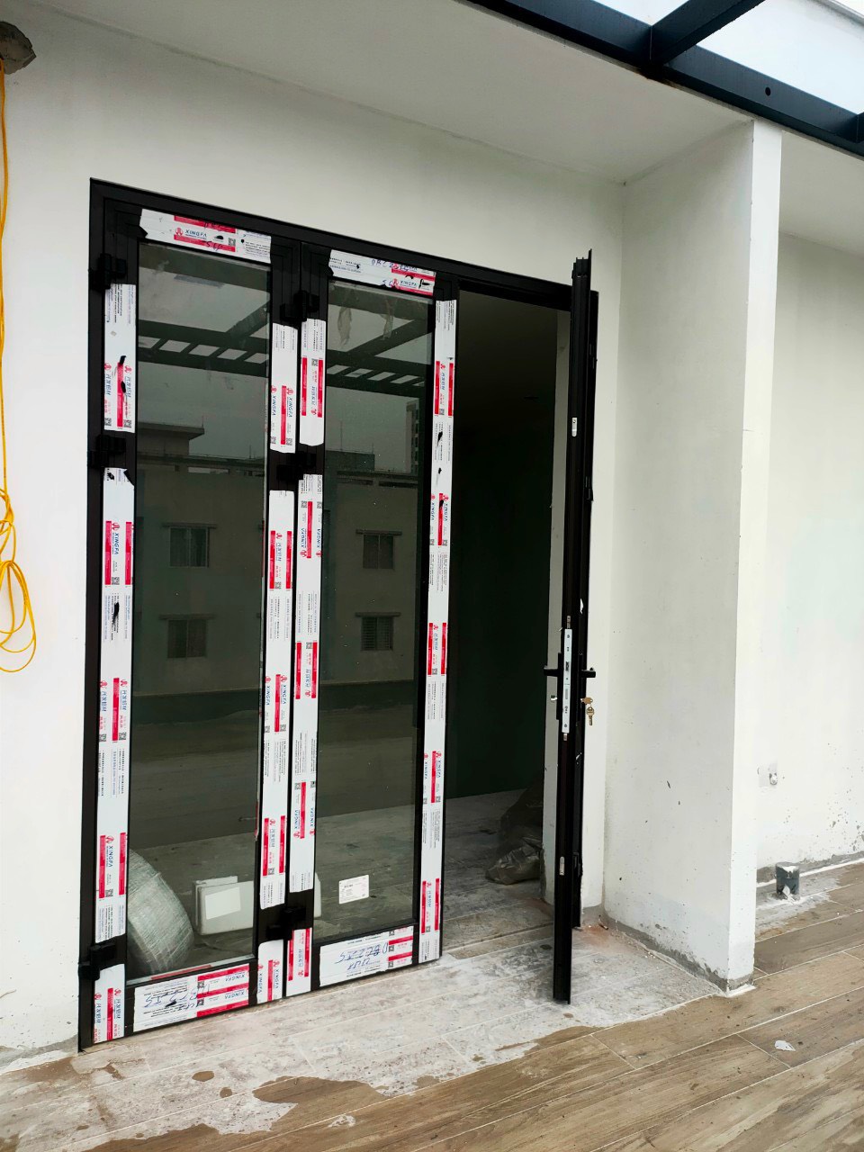 Cửa nhôm kính trượt lùa màu đen đang lắp đặt tại ban công nhà ở hiện đại